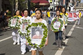 法轮功学员手持被迫害致死学员的照片