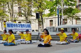 '法轮功学员在集会现场做法轮功功法演示'