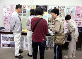 '前来参加活动的民众有的观看真相图片展，有的倾听学员介绍大法真相。'